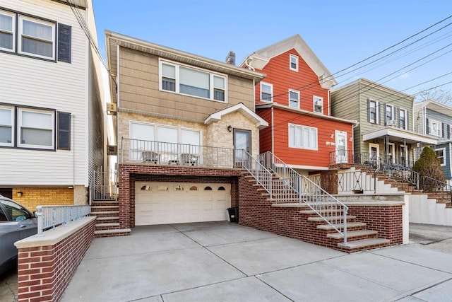 view of property with stairway, an attached garage, and driveway