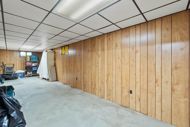 finished basement with a paneled ceiling and wooden walls