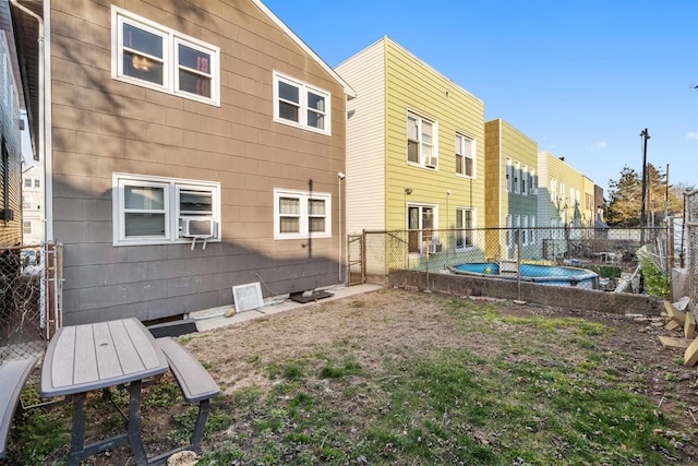 rear view of property featuring cooling unit and a fenced backyard