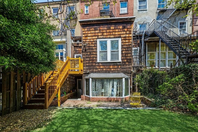 rear view of house featuring a lawn and a sunroom