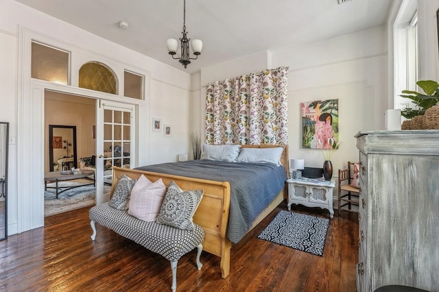 bedroom with french doors, dark hardwood / wood-style floors, and a chandelier