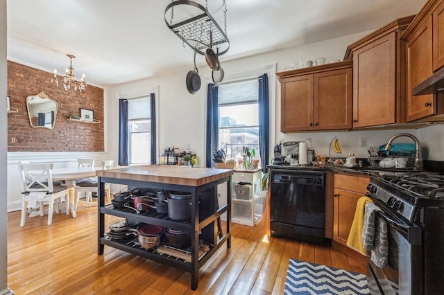 kitchen featuring brick wall, dishwasher, wood counters, light hardwood / wood-style floors, and gas range