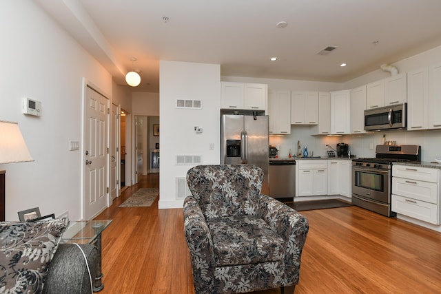 kitchen with light wood finished floors, visible vents, and appliances with stainless steel finishes