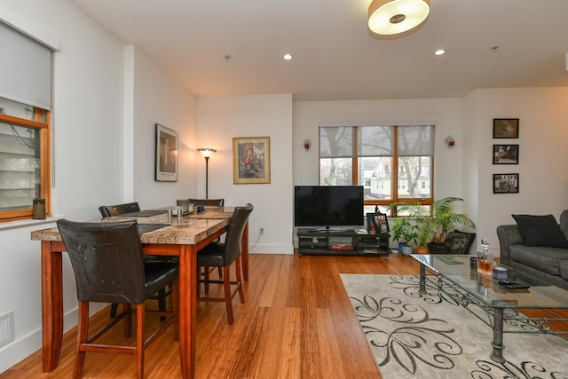 dining room with baseboards, light wood-type flooring, and recessed lighting