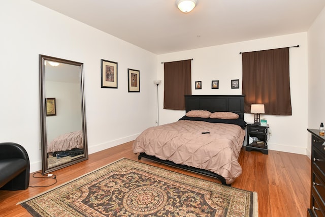 bedroom with baseboards and wood finished floors