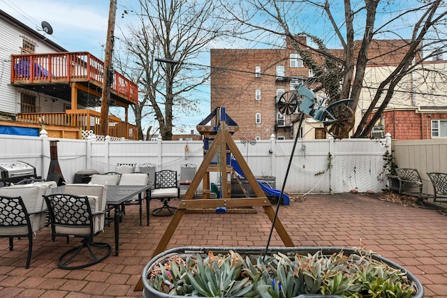 view of patio featuring a playground and a fenced backyard