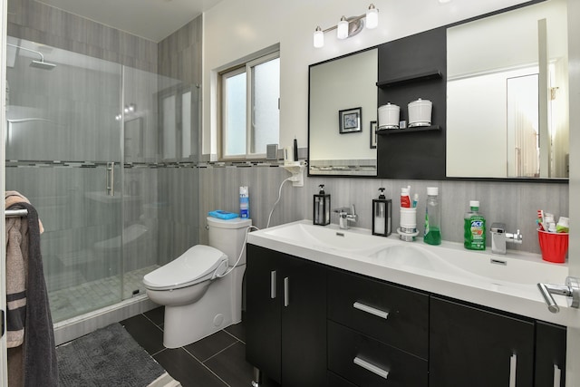 full bath featuring tile walls, double vanity, toilet, a stall shower, and tile patterned flooring