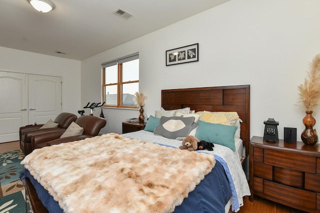 bedroom featuring visible vents, a closet, and wood finished floors