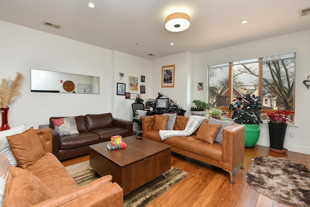 living room featuring baseboards, hardwood / wood-style floors, visible vents, and recessed lighting