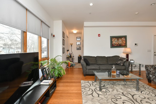 living area featuring baseboards, recessed lighting, and light wood-style floors