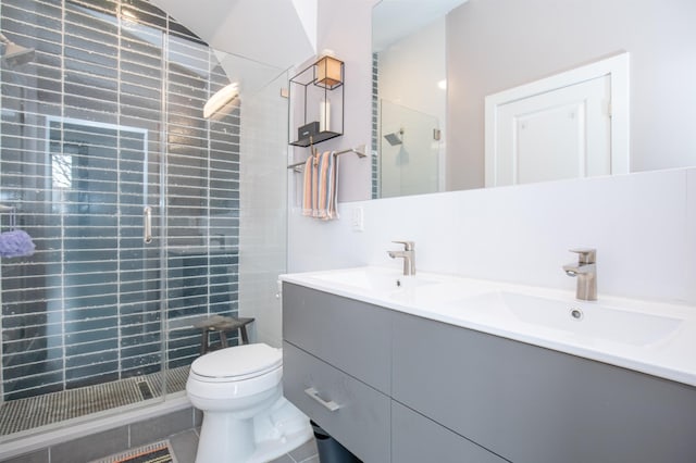 bathroom with a sink, double vanity, toilet, and a shower stall