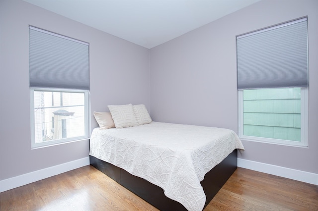 bedroom featuring wood finished floors and baseboards
