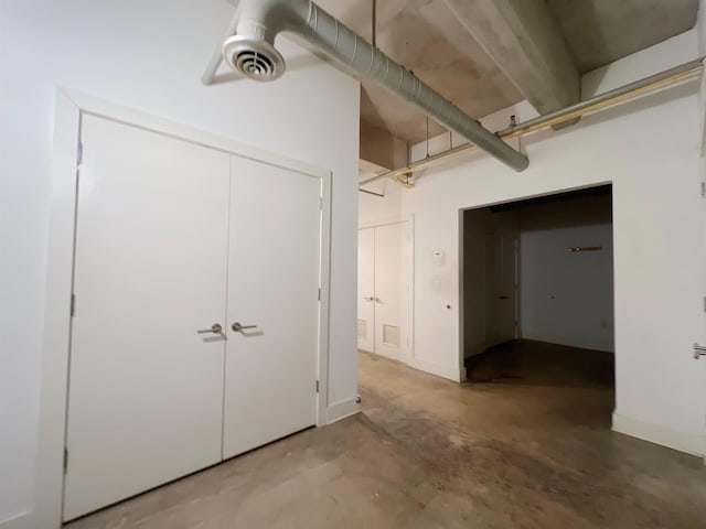 interior space featuring baseboards, a closet, visible vents, and concrete flooring