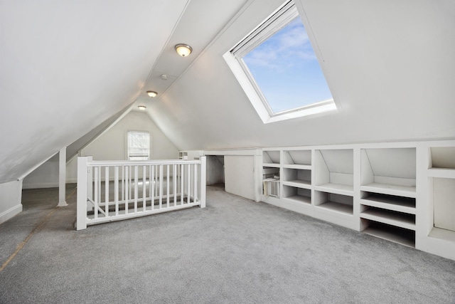 additional living space featuring lofted ceiling, built in shelves, and carpet flooring