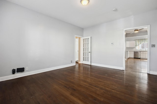 empty room with dark wood-type flooring and baseboards