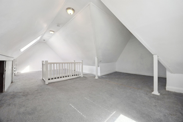 bonus room with lofted ceiling with skylight and carpet flooring