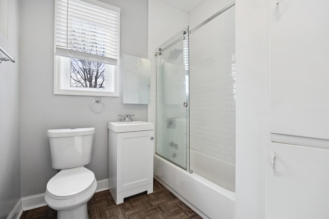 full bath with combined bath / shower with glass door, vanity, toilet, and baseboards