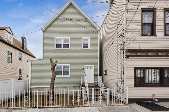 rear view of property with a fenced front yard