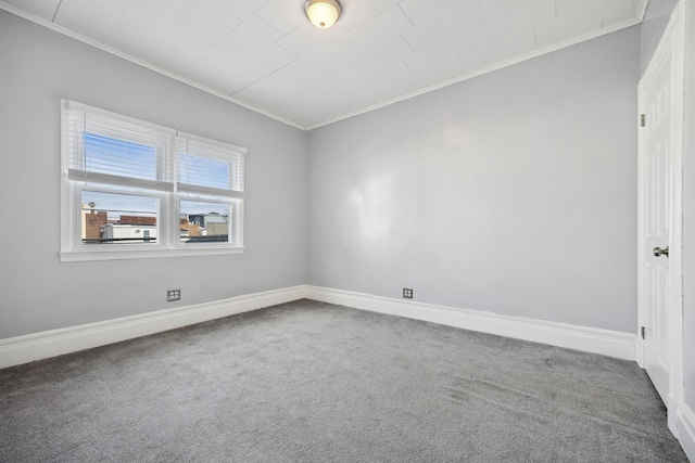 carpeted empty room with ornamental molding and baseboards