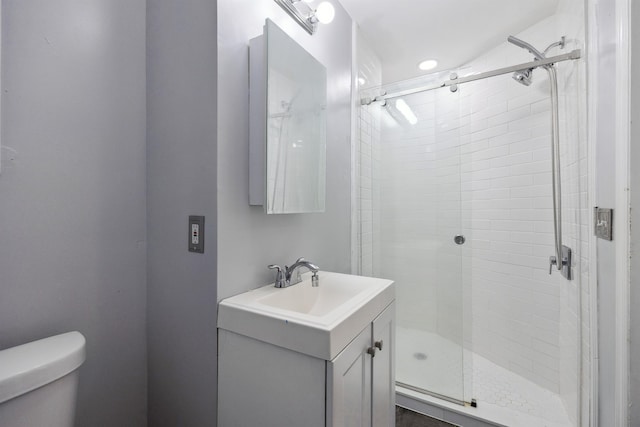 bathroom featuring a stall shower, vanity, and toilet