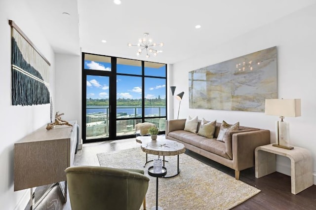 living room with hardwood / wood-style flooring, a wall of windows, and a chandelier