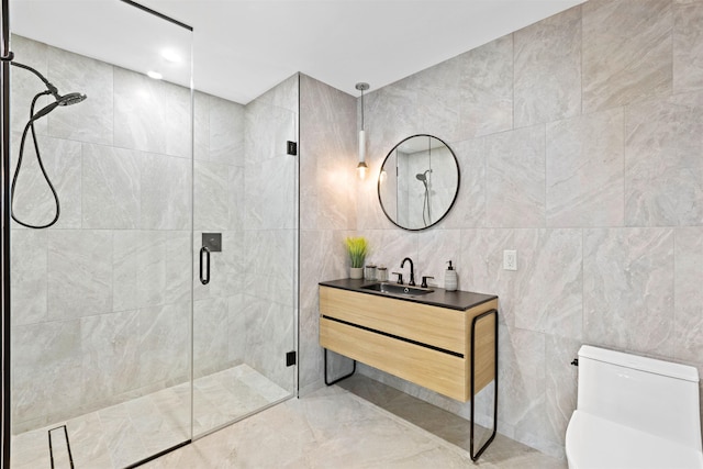 bathroom featuring vanity, toilet, a shower with door, and tile walls