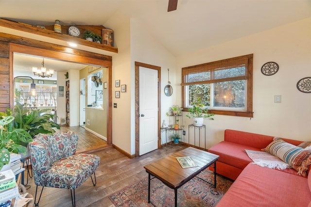 living room featuring baseboards, wood-type flooring, lofted ceiling, and a healthy amount of sunlight