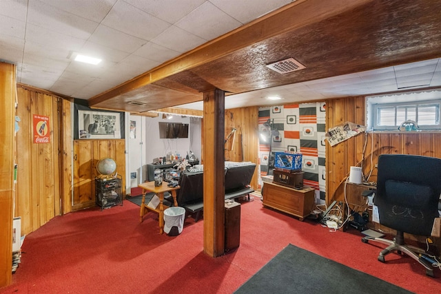 carpeted office space featuring visible vents and wooden walls