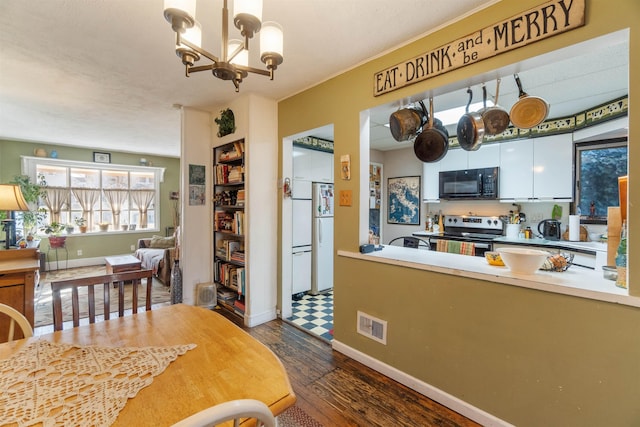 interior space featuring visible vents, baseboards, an inviting chandelier, and dark wood-style flooring