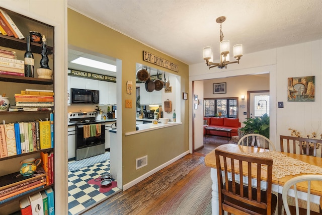 dining area with a notable chandelier, visible vents, baseboards, and wood finished floors