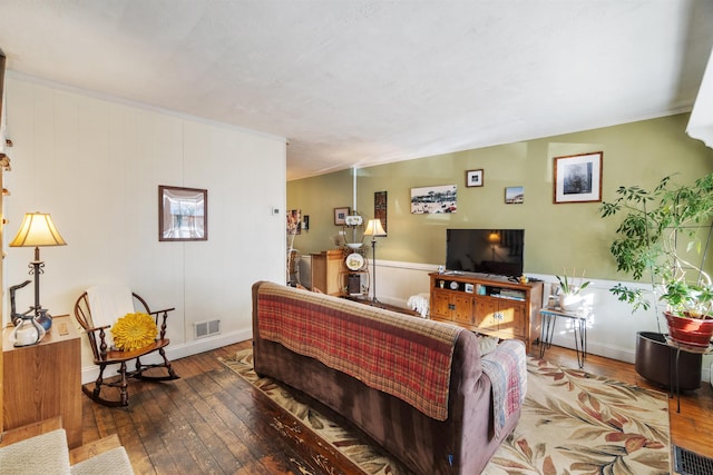 living area featuring hardwood / wood-style floors, visible vents, and ornamental molding