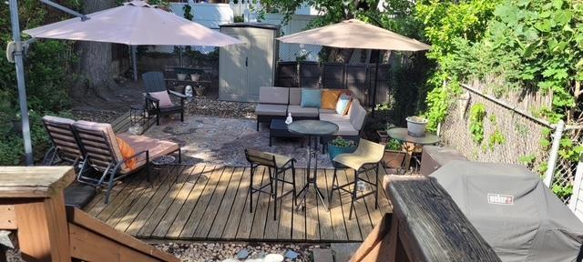 deck featuring a grill, an outdoor hangout area, and fence