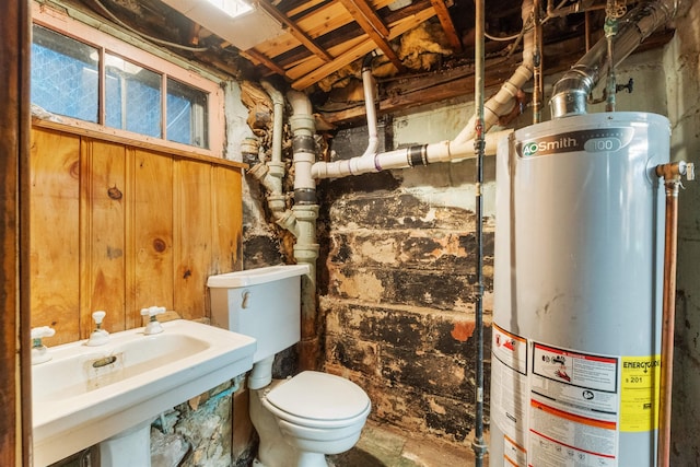 half bathroom featuring gas water heater, toilet, and a sink