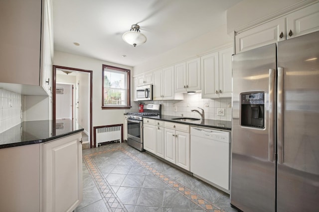 2105 Palisade Ave, Union City, NJ 07087 - kitchen with appliances with stainless steel finishes, radiator heating unit, a sink, backsplash, and inlaid floor details