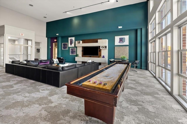 playroom with carpet, rail lighting, and a towering ceiling