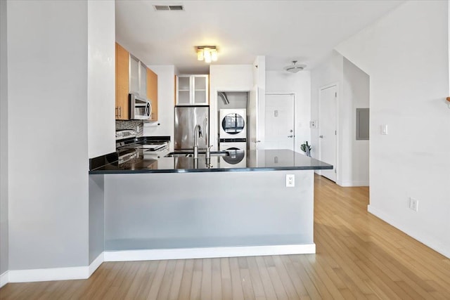 kitchen with dark countertops, visible vents, appliances with stainless steel finishes, light wood-type flooring, and a peninsula