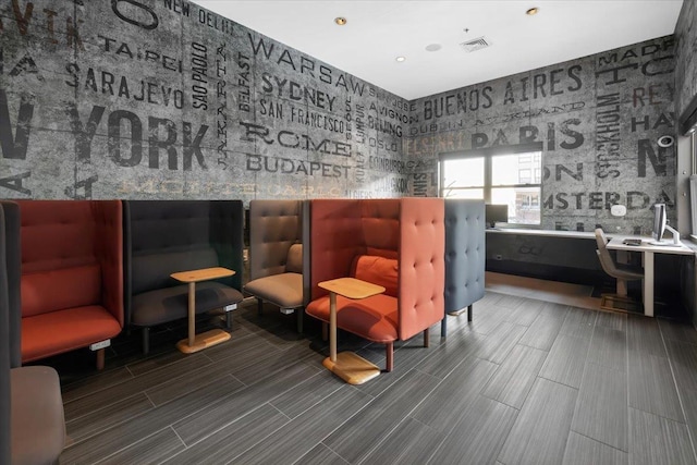 living area with visible vents and wallpapered walls