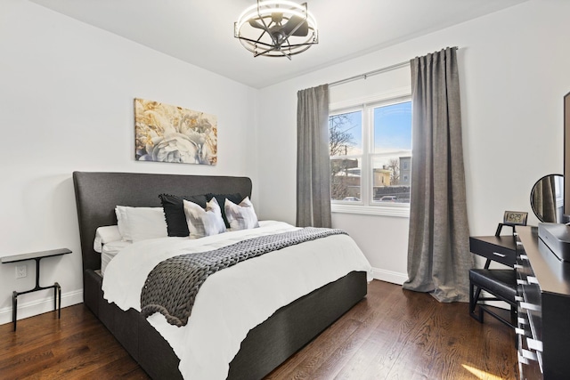 bedroom featuring dark wood-type flooring and a notable chandelier