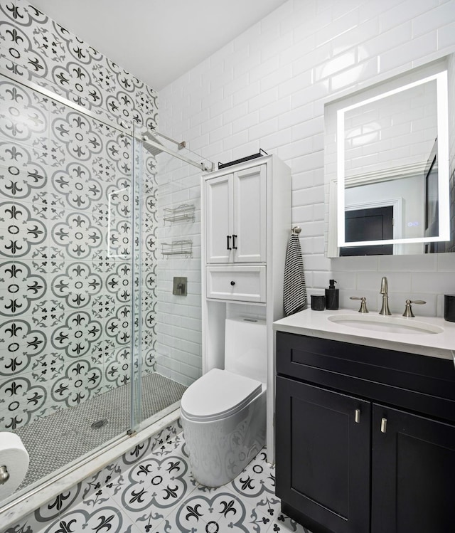 bathroom featuring tile patterned flooring, backsplash, toilet, walk in shower, and vanity