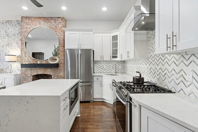 kitchen featuring tasteful backsplash, white cabinetry, ventilation hood, stainless steel appliances, and dark hardwood / wood-style floors