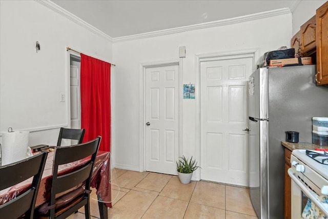 dining room with light tile patterned floors and crown molding