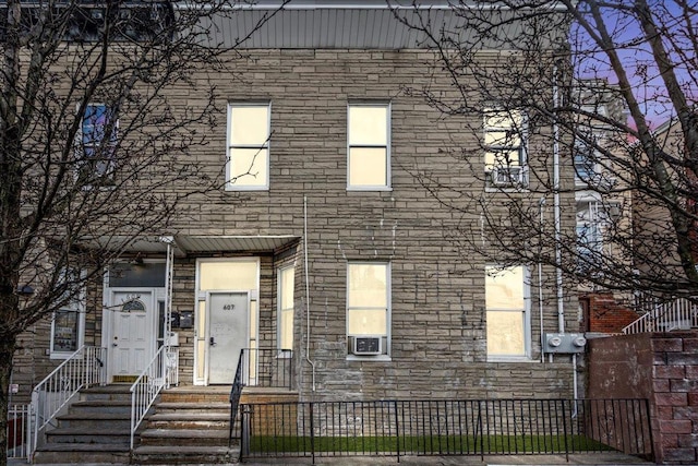 view of front of home with a fenced front yard and stone siding