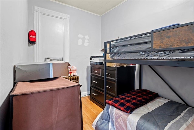 bedroom with light wood-type flooring and ornamental molding