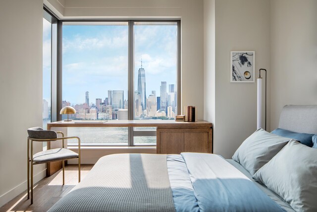 99 Hudson St Unit 2806, Jersey City, NJ 07302 - bedroom with multiple windows, a skyline view, and wood finished floors