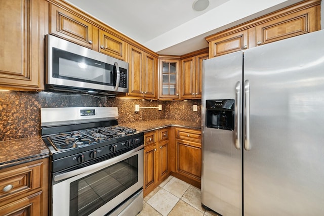 45 Broadway Unit 204, Jersey City, NJ 07306 - kitchen with appliances with stainless steel finishes, brown cabinetry, tasteful backsplash, and glass insert cabinets