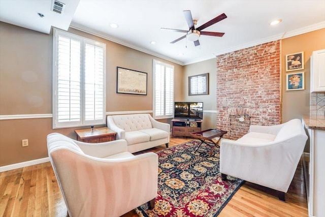 living room featuring light hardwood / wood-style floors, a healthy amount of sunlight, and ornamental molding