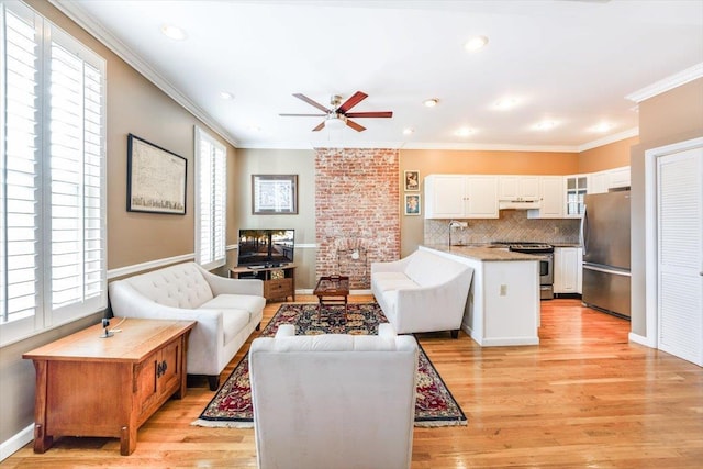 living room with light hardwood / wood-style floors, ceiling fan, and crown molding