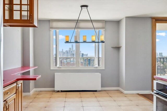 380 Mountain Rd Unit 213, Union City, NJ 07087 - unfurnished dining area featuring radiator heating unit, a skyline view, and plenty of natural light