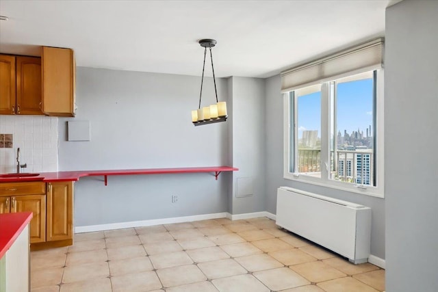 380 Mountain Rd Unit 213, Union City, NJ 07087 - kitchen featuring radiator heating unit, tasteful backsplash, hanging light fixtures, and brown cabinets