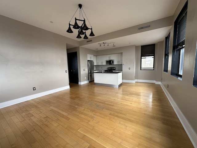 4 Beacon Way Unit 1001, Jersey City, NJ 07304 - unfurnished living room featuring a chandelier, light wood-type flooring, and baseboards